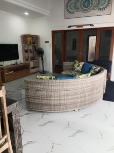 a living room with a couch and a television at Wyanna Villa LEGIAN in Legian