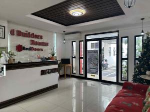 ein Restaurant mit einer roten Couch in einem Zimmer in der Unterkunft D'Builders Rooms Hotel in Sampong