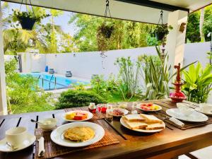 a wooden table with breakfast food on it at Gone4Coastal - Cabana in Hikkaduwa