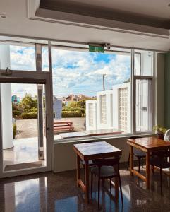 a room with two tables and a large window at 純粹Home 民宿 in Shui-wa-chüeh