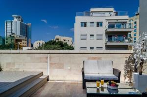 a balcony with a chair and a table on a building at Ness Hotel in Tel Aviv