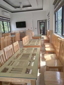a dining room with tables and chairs and a television at Seagull Hotel in Cat Ba