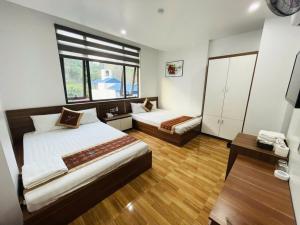 a bedroom with two beds and a window at Seagull Hotel in Cat Ba