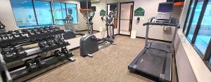 a gym with treadmills and machines in a building at Hotel Willowbrook in Houston +4 photos