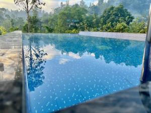 a swimming pool with a reflection in the water at Monaara Leisure - Ella in Ella