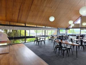 a dining room with tables and chairs and windows at Fiordland Hotel in Te Anau