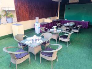 a dining room with tables and chairs and a screen at Hotel Rivlet By Carlton Suites in Gurgaon