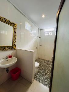 a bathroom with a sink and a toilet and a mirror at Puji Bisma Ubud in Ubud +13 photos
