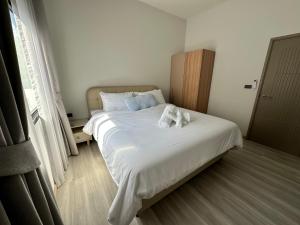 a bedroom with a bed with two towels on it at 2 Bedroom Modern House in Ban Nong Chaeng