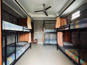a room with four bunk beds and a ceiling fan at Puji Bisma Ubud in Ubud