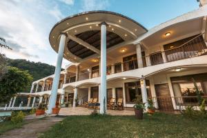 an exterior view of a large building with a patio at Hotel Mercy in San Juan La Laguna