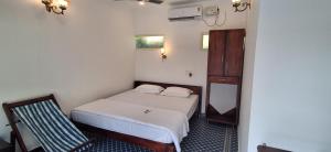 a small bedroom with a bed and a chair at Mudra beach villa Gokarna in Gokarna