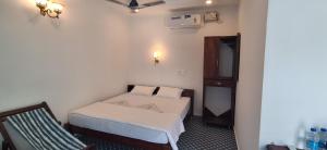 a small room with a bed and a chair at Mudra beach villa Gokarna in Gokarna