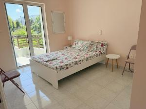 a small bedroom with a bed and a balcony at Zeus Beach Condo in Vernardhaíika