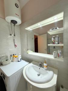 a bathroom with a white sink and a mirror at Zeus Beach Condo in Vernardhaíika +35 photos