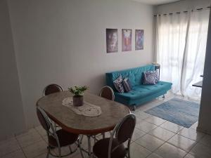 a living room with a table and a blue couch at Aconchego II in Juiz de Fora