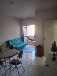 a living room with a blue couch and a table at Aconchego II in Juiz de Fora +8 photos