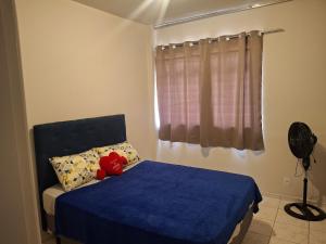 a bedroom with a blue bed and a window at Aconchego II in Juiz de Fora