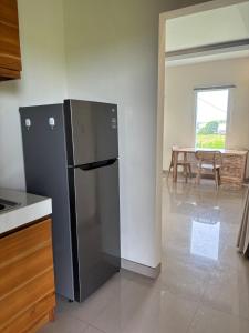 a black refrigerator in a kitchen with a table at Private Studio Near Kedungu Beach Cozy & Affordable in Tanah Lot +48 photos