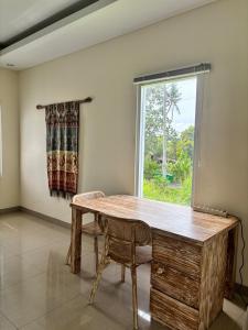 a dining room with a wooden table and a window at Private Studio Near Kedungu Beach Cozy & Affordable in Tanah Lot