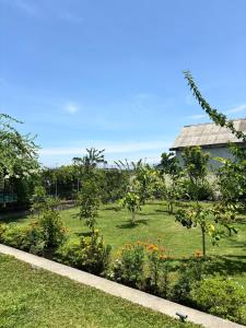 a garden with flowers and trees and a building at Private Studio Near Kedungu Beach Cozy & Affordable in Tanah Lot