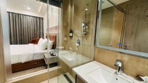 a bathroom with a bed and a sink and a shower at Regenta Central Jaipur in Jaipur