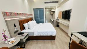 a hotel room with a bed and a television at Regenta Central Jaipur in Jaipur +93 photos