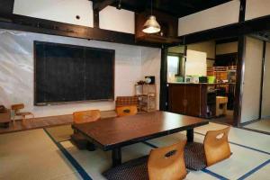 a classroom with a table and chairs and a chalkboard at Rebe東吉野 in Higashiyoshino