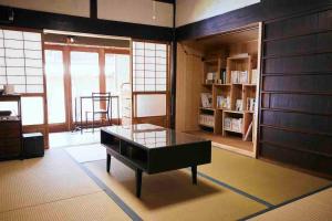 a living room with a table and a book shelf at Rebe東吉野 in Higashiyoshino