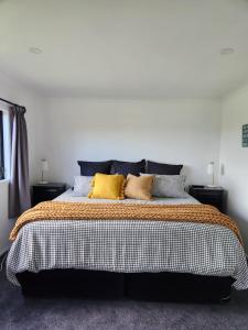 a bedroom with a large bed with three pillows at Mill Road Retreat Ohaupo in Kaipaki