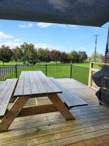 a wooden picnic table on a wooden deck at Mill Road Retreat Ohaupo in Kaipaki +1 photo