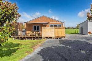 a house with a large deck in the yard at Mill Road Retreat Ohaupo in Kaipaki
