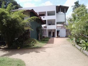 an apartment building with a pathway in front of it at Wijaya Garden Hotel in Anuradhapura