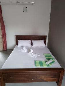 a bed with white sheets and towels on it at Wijaya Garden Hotel in Anuradhapura