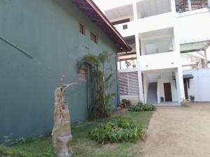 a blue building with a tree stump in front of it at Wijaya Garden Hotel in Anuradhapura
