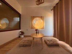 a living room with a table and a window at บ้านซินอัน in Ban Rak Thai