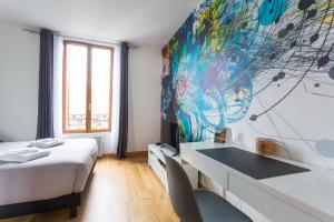 a bedroom with a bed and a desk and a painting at The Pearl in Vitry-sur-Seine