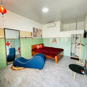 a bedroom with a bed and a blue couch at Motel NHÀ SAM in áº¤p VÄ©nh ÃÃ´ng
