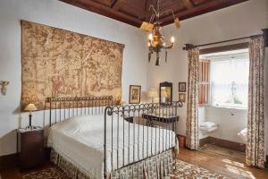 a bedroom with a bed and a tapestry on the wall at Casa de Canedo in Celorico de Basto +32 photos