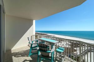 a balcony with a table and chairs and the beach at Catalina 902-Updated Beachfront Condo with Amazing Views-Full Service Resort in Gulf Shores
