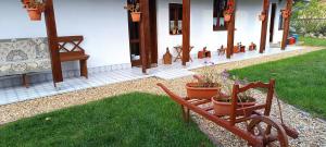 a bench with potted plants sitting in front of a house at Vándor Kakas Vendégház dézsafürdővel in Recsk