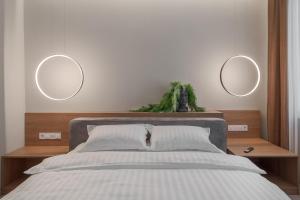 a bedroom with a bed with two mirrors on the wall at Oasis Rooms Oradea in Oradea +34 photos