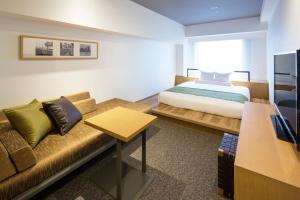 een hotelkamer met een bed en een bank bij HOTEL MYSTAYS PREMIER Omori in Tokyo