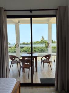 a dining room with a table and chairs on a balcony at Crossing Royal in Mirissa