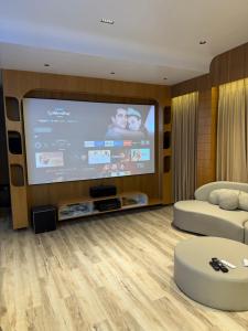 a living room with a flat screen tv and a couch at Hotel victoria prime in Surat