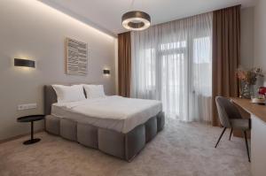 a hotel room with a bed and a desk and a desk at Oasis Rooms Oradea in Oradea