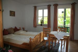 a bedroom with a bed and a table and chairs at Gasthaus Marienhof in Kirchdorf am Inn