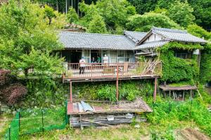 a house with people standing on a wooden deck at Rebe東吉野 in Higashiyoshino