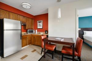 a kitchen with a refrigerator and a table and chairs at Residence Inn by Marriott Chicago O'Hare in Rosemont +17 photos