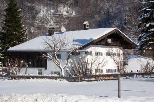 un edificio blanco cubierto de nieve con árboles en Windshausen 84 en Nußdorf am Inn